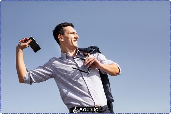 A man tossing away his cell phone